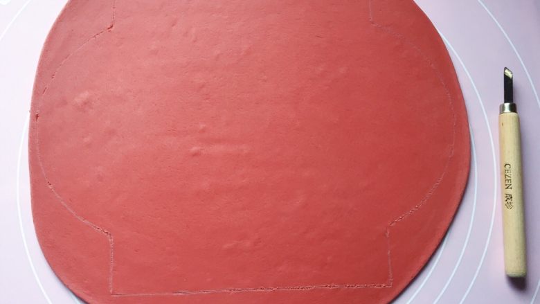五福灯笼,将发酵好的面团分别排气揉匀后，取一红色面团擀成1cm厚的面片，然后用美工刀刻画出一个高18cm、宽（直径）20cm的灯笼形状。