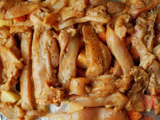 无油的香喷喷烤鸡腿肉,接下来将腌制好的鸡腿肉条，铺在放有土豆的烤盘上。