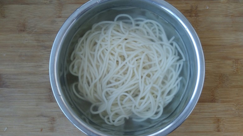 快手酸汤面,把煮熟的面条捞入凉开水中。