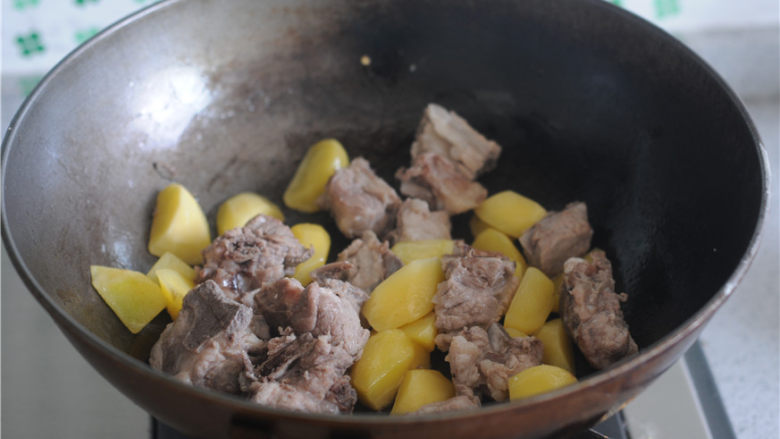黑胡椒酱烧土豆,将排骨也倒入锅里，一起翻炒至排骨表面焦黄