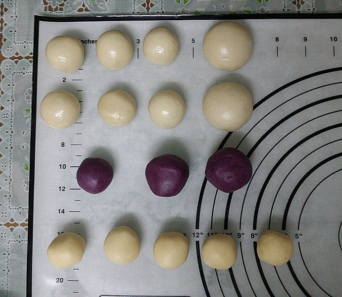 双色蛋黄酥,取出静置好的油皮：秤重分成10分等份、再将其中4等分合并成2等份，既2大6小合计8份； 取出油酥：将白色和紫色油酥，分别秤重分成5小份，再将其中4份紫色油酥合并成2等份、既2大1合计3份，如图搓圆备用