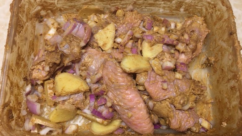 咖喱孜然烤鸡翅,最后将生姜片、洋葱碎倒入混和均匀，盖上盖子，放冰箱至少冷藏6小时。
