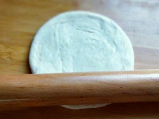 做饼＋饼夹鲜嫩牛肉,将小面团的两头捏紧。将小面团立再面板上，用手心压扁，然后再用擀面杖擀开，约12cm左右圆形。