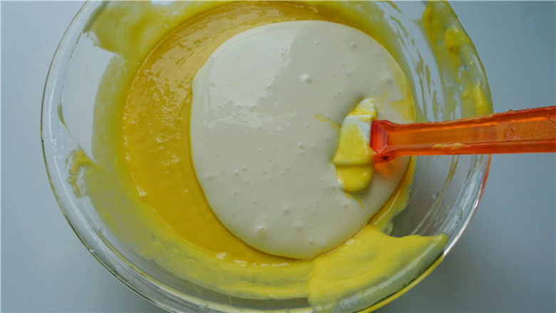 芒果淋面慕斯蛋糕,将淡奶油加入奶酪芒果泥里，翻版均匀。