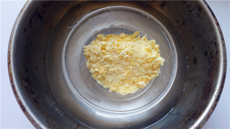 芒果淋面慕斯蛋糕,白巧克力隔水融化（切勿高温，勿超过42℃），溶化后离火静置待用。