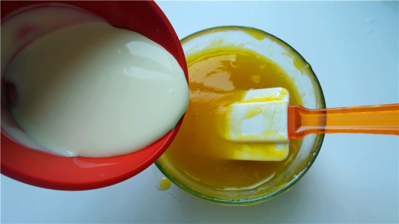 芒果淋面慕斯蛋糕,将淡奶油加入到芒果糖浆中，拌匀。