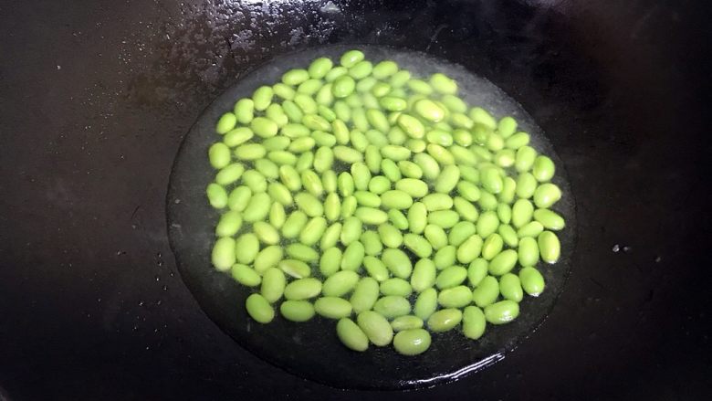油豆腐焖毛豆,炒至变成碧绿色加入半碗水