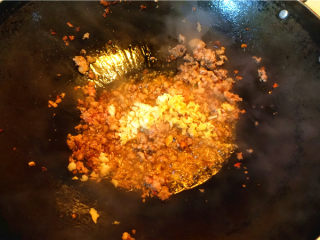 肉末烧豆腐皮,炒至肉糜变色，放入姜蒜末炒香，混合炒匀。