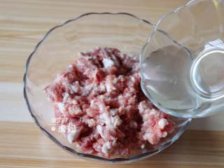 蟹粉狮子头,花椒水分3次加入肉糜中，用筷子同一个方向搅拌均匀；