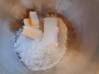 葡萄干奶酥,将软化的黄油、白砂糖、奶粉放入打蛋盆；