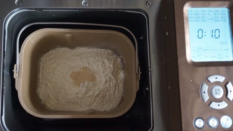 肉桂核桃面包卷,加上面粉，在面粉顶端加上酵母，将面包桶放入到东菱1352AE-3C面包机里，启动面包机的和面程序10分钟