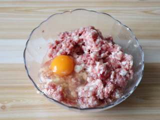 蟹粉狮子头,加入鸡蛋，筷子顺时针搅拌几分钟搅打上劲；