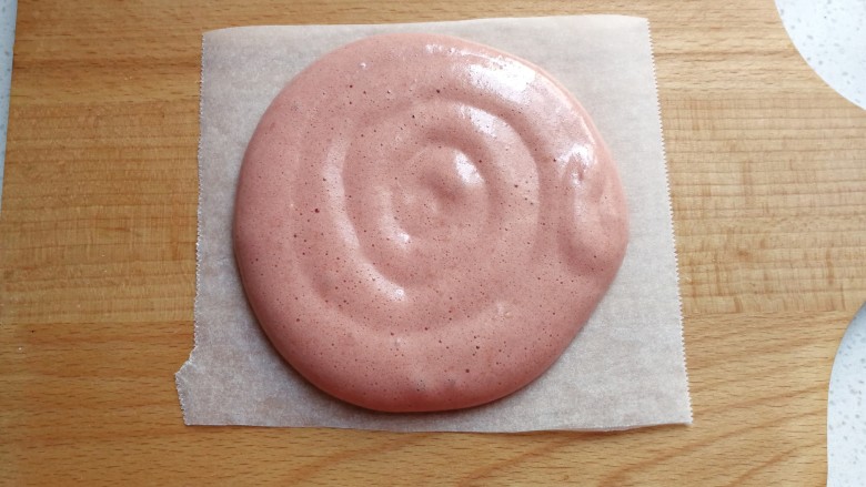 草莓奶油红曲小卷,裱花袋剪一个圆孔，然后在方形油纸上挤上圆形蛋糊；（方形油纸提前裁剪好备用）