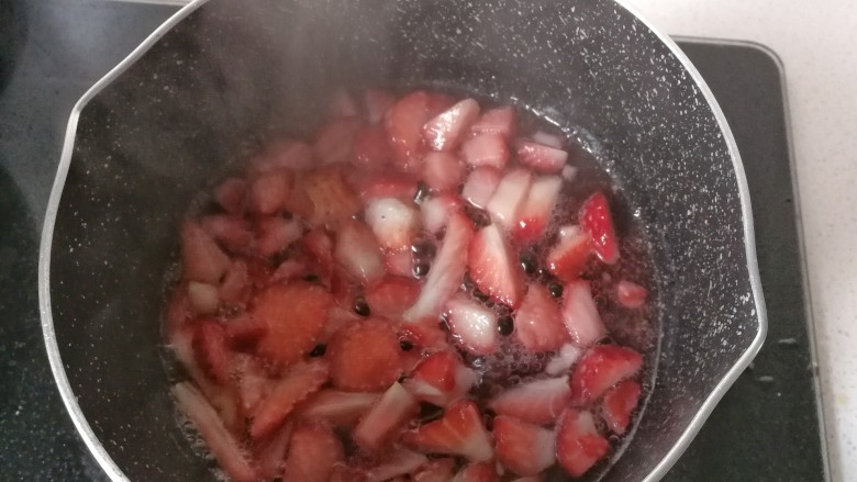 草莓奶油红曲小卷,然后放入不粘锅，加两勺白糖和少许清水熬煮，中途要适时翻炒几下；