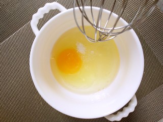 #宝宝零食#芝麻薄脆饼干,鸡蛋加入玉米油和糖，搅拌混合均匀