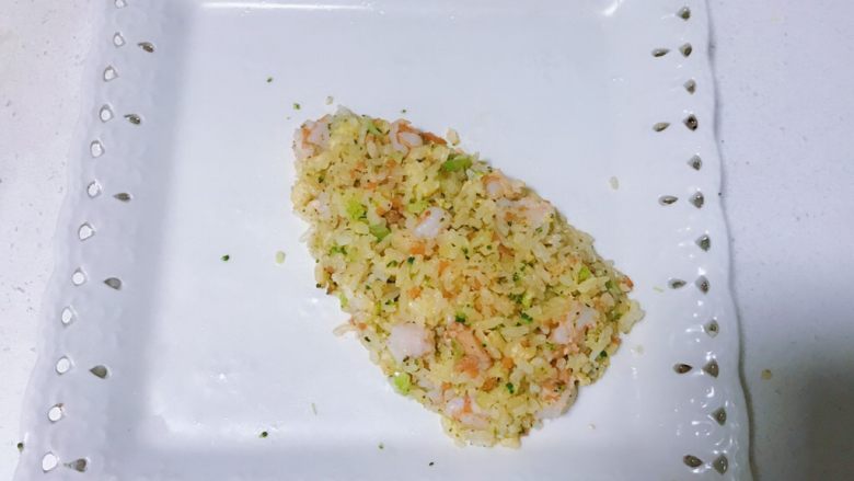 菠萝造型黄金海鲜炒饭,将米饭盛出，在盘子里摆放成上小下大的菠萝形状