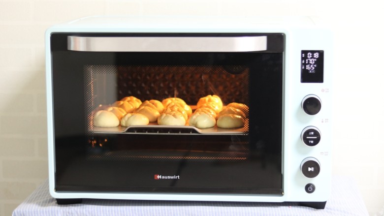 蓝莓乳酪面包,放入预热好的烤箱。上火170度，下火165°，18分钟即可