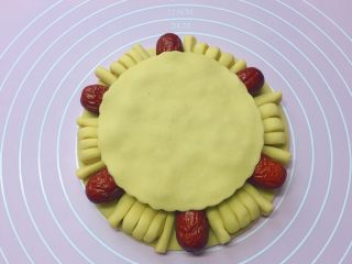枣花馍,取一面团擀开，用一个比底盘稍小一号的圆形模具压出一个圆饼盖上。