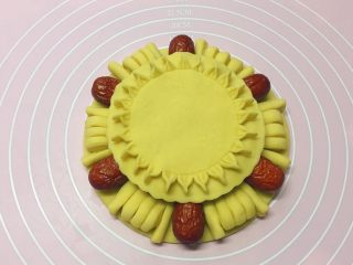 枣花馍,如图：把做好的花形圆饼放在枣花馍上。