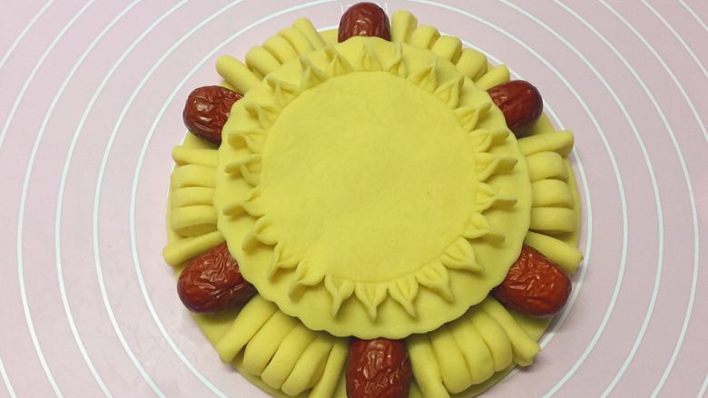 枣花馍,如图：把做好的花形圆饼放在枣花馍上。