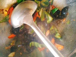 家常肥肠,放入青椒，胡萝卜，木耳煸炒至软加入半勺酱油。