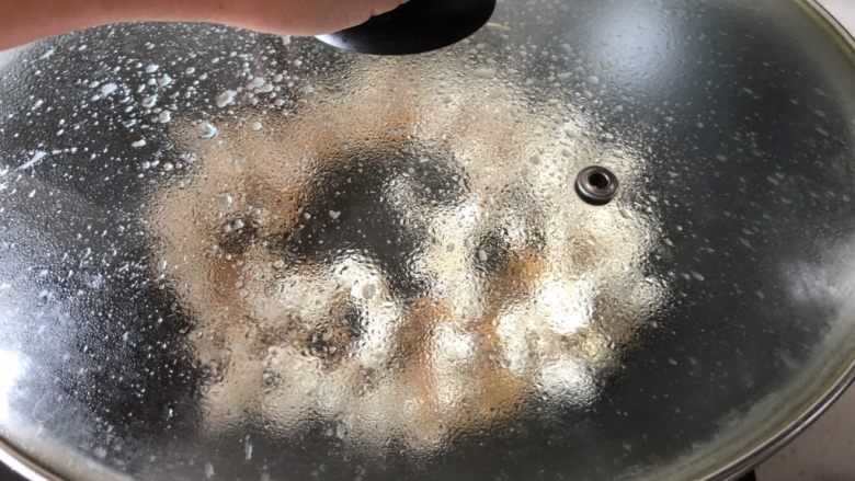 焦糖爆米花,一手按锅盖，一手晃动锅子，使玉米粒受热均匀，更快爆好