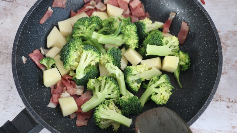 西蓝花土豆培根浓汤,加入焯烫好的蔬菜继续翻炒。