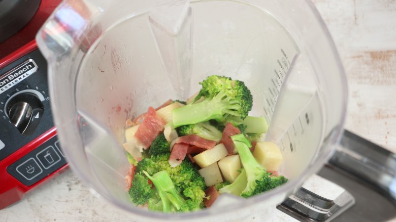 西蓝花土豆培根浓汤,将炒熟的蔬菜倒入汉美驰破壁机的料理杯中。
