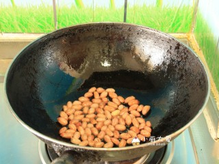 过年开胃菜---酸辣蕨根粉,炒锅烧干后放入适量的食用油，倒入花生仁，小火慢慢炒熟