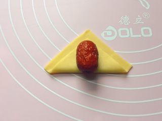 红红火火枣花馍,将正方形面片对折，然后在上面放一个红枣（红枣提前泡发 2分钟，然后清洗干净备用）。