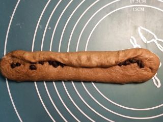 巧克力双色吐司面包,一边卷一边用两个大拇指按压接缝。