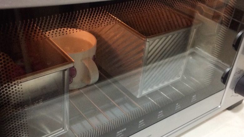 巧克力双色吐司面包,放进烤箱最低层，冬天开启发酵模式（夏天环境温度高不开也可以），里面放一杯热开水。