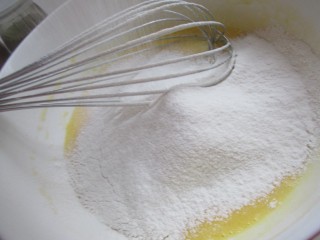彩虹奶油蛋糕,蛋黄和玉米油牛奶一起拌匀，筛入低筋面粉。