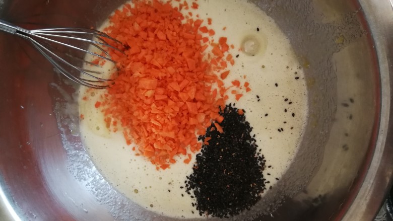 胡萝卜蛋糕,之后把切好的胡萝卜碎和黑芝麻放入搅拌均匀的鸡蛋和糖的糊中继续搅拌均匀