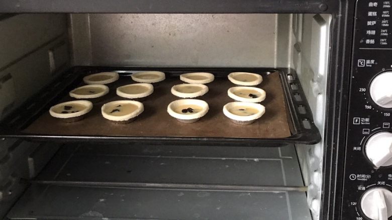 炼乳版全蛋蜜豆蛋挞,放入预热好的烤箱的中层，180度上下火烤18分钟后调到200度上火烤到上色