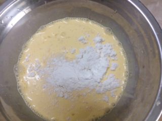 葡式蛋挞,倒入过筛后的低筋面粉与吉士粉搅拌混合均匀。