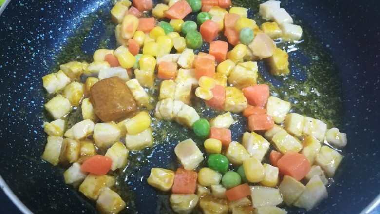 快手鸡肉咖喱塔,放入解冻的蔬菜丁，仍然是小火，慢慢将咖喱炒化。