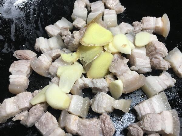 豆角烧肉,锅内放入少许油，把五花肉和葱姜蒜片一起翻炒