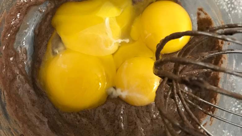 数字蛋糕,将蛋黄放入面糊中，继续用手动打蛋器搅拌。