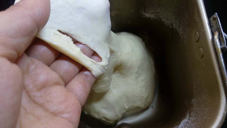 肉松面包卷,打至能拉出厚膜的状态，注意调整好面团的干湿度，面粉的吸水率和季节不同，预留总水量的10%左右，视面团的状况来加。