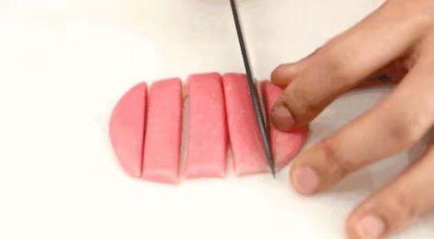 绣球蛋黄酥,用刀子将长方形面团平均分成5条， 再把每条中间切开，5条再分成10条长条。红、绿面团一样制作。