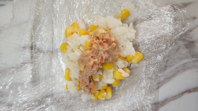 金枪鱼三色饭团,保鲜膜叠三层，放入米饭，中间放入金枪鱼，