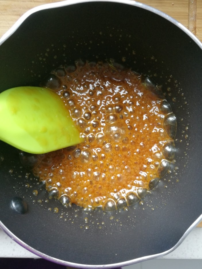 配一脸的焦糖核桃香蕉慕斯,12. 加入一勺淡奶油跟水的混合液，大概30毫升，这时候焦糖液会冒大泡，然后继续加热小火，混合均匀，千万不要一次性加入淡奶油跟水，会喷的到处都是