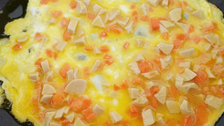 做饼～火腿肠胡萝卜鸡蛋饼,把混合好的鸡蛋液倒入锅中