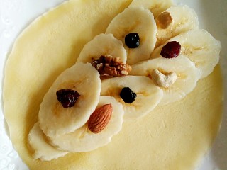 香蕉坚果可丽饼,在可丽饼上摆上香蕉和坚果。