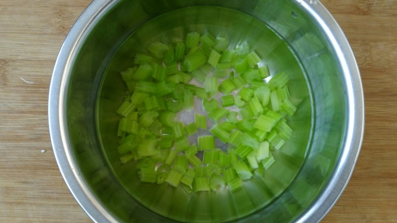 香芹拌豆干,把焯熟的香芹捞入凉水中。