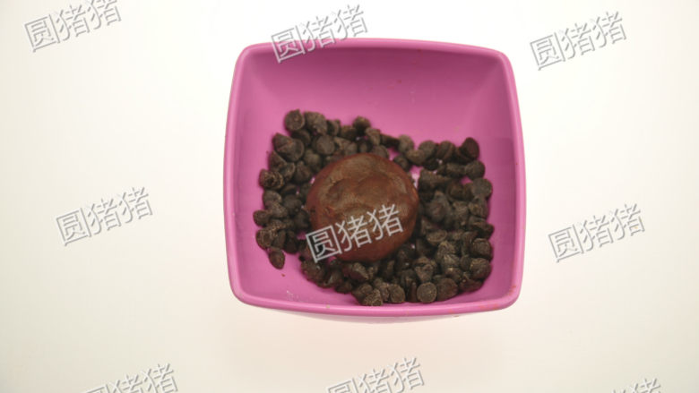 巧克力豆曲奇,取一小碗装上30克巧克力豆，放入圆球，使其表面粘上巧克力豆。