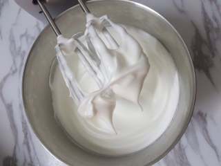 豆乳奶油奶酪戚风,这时烤箱预热170℃，取出冷冻的蛋白，分三次加入糖B，先高速，后中速最后低速整理气泡，打至接近硬性发泡，提起有直立尖角