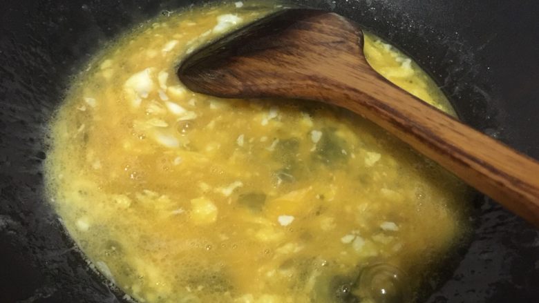 做饼+韭菜鸡蛋馅饼,锅里热油后将鸡蛋液倒入锅中炒
