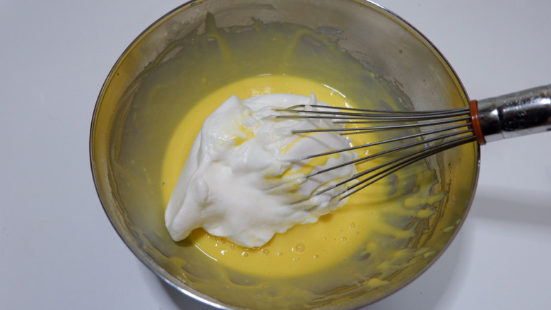 奶油奶酪戚风蛋糕,先取1/3蛋白加入奶酪糊中，翻拌均匀。